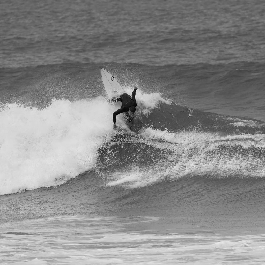Surfista fazendo manobra na onda